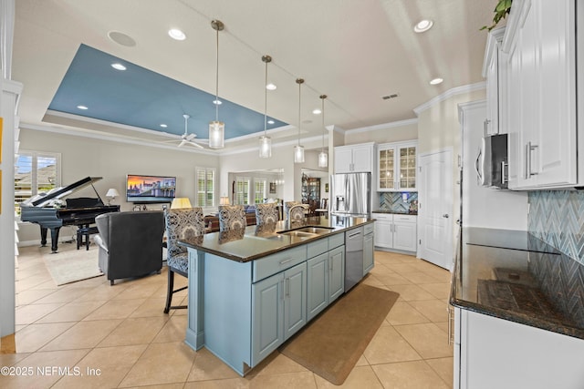 2144 S Sorrento Hills Rd, Saint Augustine, FL 32092 - kitchen with appliances with stainless steel finishes, white cabinets, ornamental molding, light tile patterned flooring, and a kitchen bar