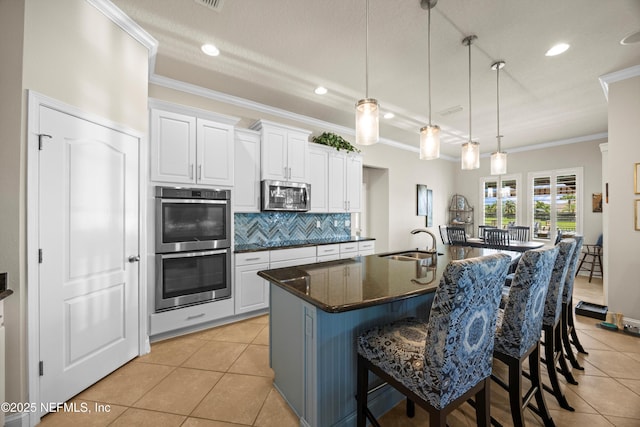 2144 S Sorrento Hills Rd, Saint Augustine, FL 32092 - kitchen featuring stainless steel appliances, crown molding, light tile patterned flooring, tasteful backsplash, and white cabinets