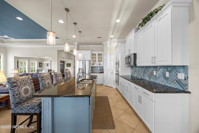 2144 S Sorrento Hills Rd, Saint Augustine, FL 32092 - kitchen with crown molding, appliances with stainless steel finishes, decorative backsplash, open floor plan, and a breakfast bar