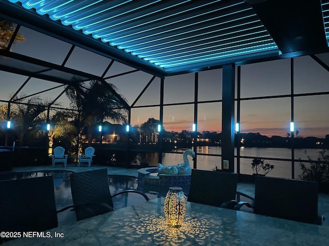 2148 S Sorrento Hills Rd, Saint Augustine, FL 32092 - patio terrace at dusk with a patio area, outdoor dining space, glass enclosure, a water view, and a pool with connected hot tub
