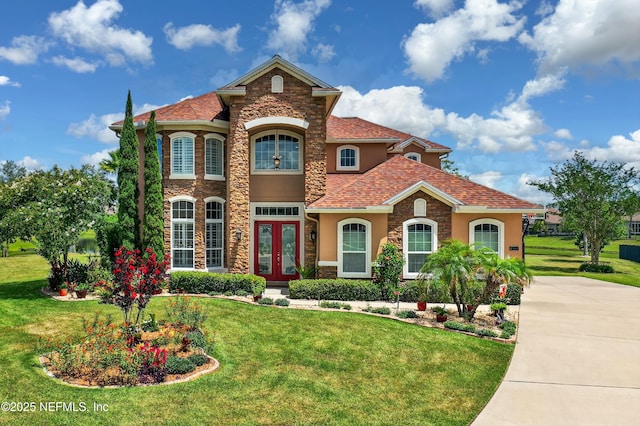 2148 S Sorrento Hills Rd, Saint Augustine, FL 32092 - view of front of home featuring french doors, stucco siding, a front lawn, and stone siding