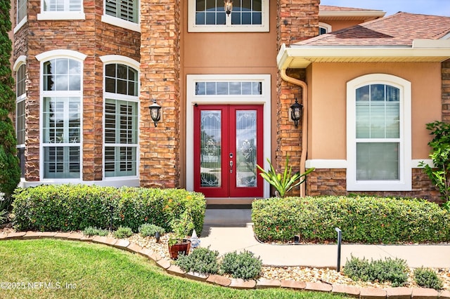 2148 S Sorrento Hills Rd, Saint Augustine, FL 32092 - doorway to property featuring stone siding, stucco siding, french doors, and a shingled roof