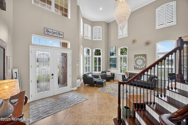 2148 S Sorrento Hills Rd, Saint Augustine, FL 32092 - entrance foyer featuring a high ceiling, ornamental molding, french doors, a chandelier, and stairs