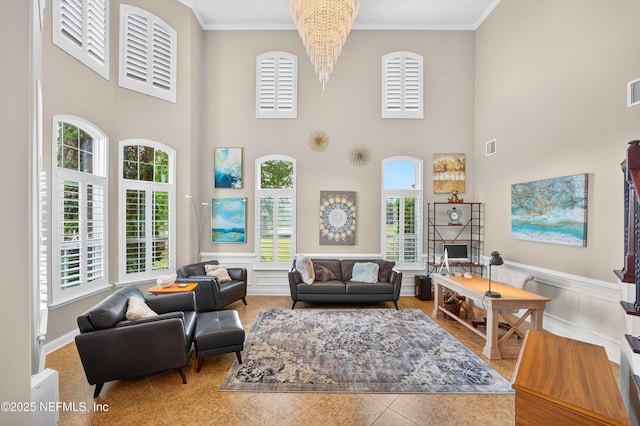 2148 S Sorrento Hills Rd, Saint Augustine, FL 32092 - living area featuring crown molding, a towering ceiling, a wainscoted wall, a chandelier, and a decorative wall