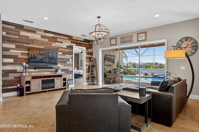 2148 S Sorrento Hills Rd, Saint Augustine, FL 32092 - living room featuring wood walls, arched walkways, a chandelier, recessed lighting, and an accent wall