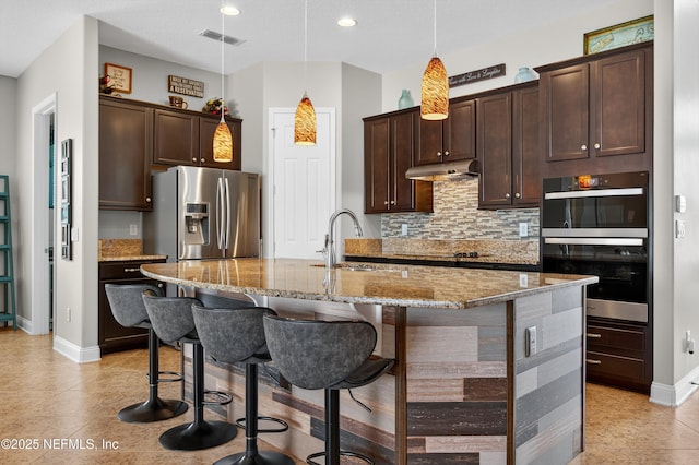 2148 S Sorrento Hills Rd, Saint Augustine, FL 32092 - kitchen with appliances with stainless steel finishes, dark brown cabinets, light stone counters, and recessed lighting