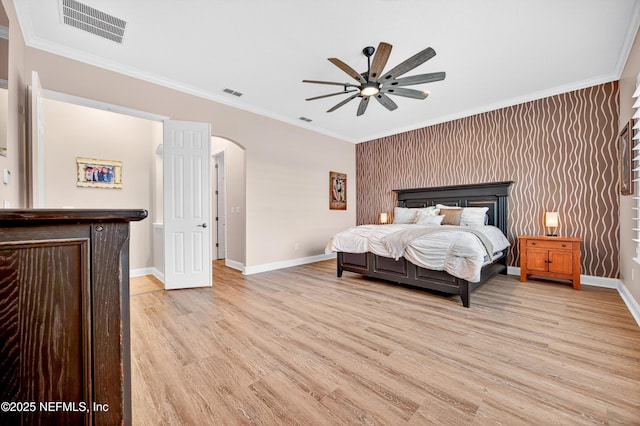 2148 S Sorrento Hills Rd, Saint Augustine, FL 32092 - bedroom featuring arched walkways, light wood-style flooring, crown molding, and a ceiling fan