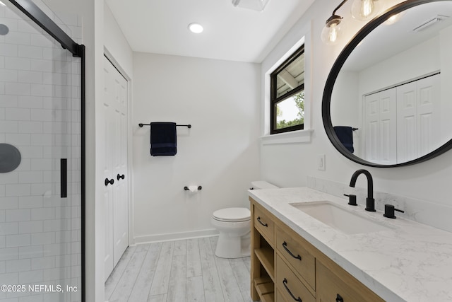 1381 Forrest Dr, Fernandina Beach, FL 32034 - bathroom with vanity, toilet, a closet, a tile shower, and wood finished floors