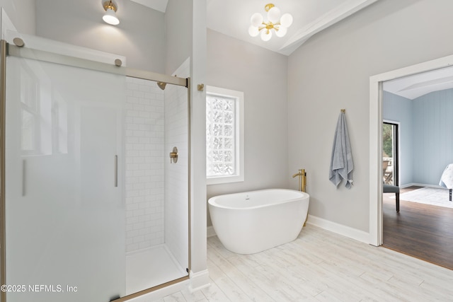 1381 Forrest Dr, Fernandina Beach, FL 32034 - bathroom featuring a stall shower, a soaking tub, baseboards, wood finished floors, and a chandelier
