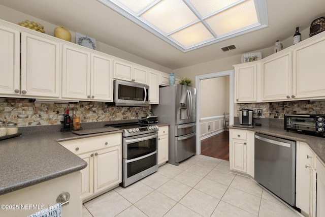 1766 Buttonbush Way, Fleming Island, FL 32003 - kitchen with stainless steel appliances, dark countertops, light tile patterned floors, and backsplash