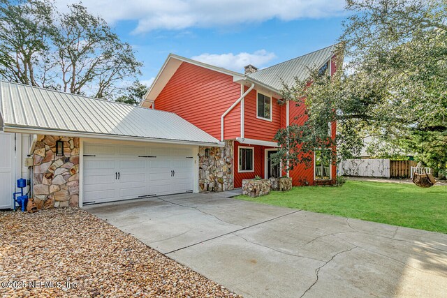 4 Santa Maria Ln, Saint Augustine, FL 32080 - view of front of home featuring stone siding, concrete driveway, metal roof, and a chimney