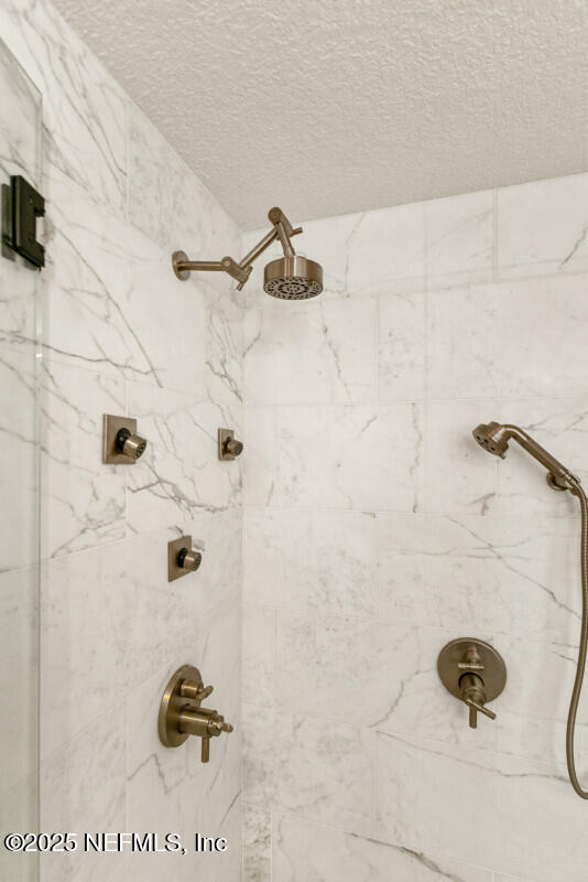 4 Santa Maria Ln, Saint Augustine, FL 32080 - bathroom view of a tile shower and a textured ceiling