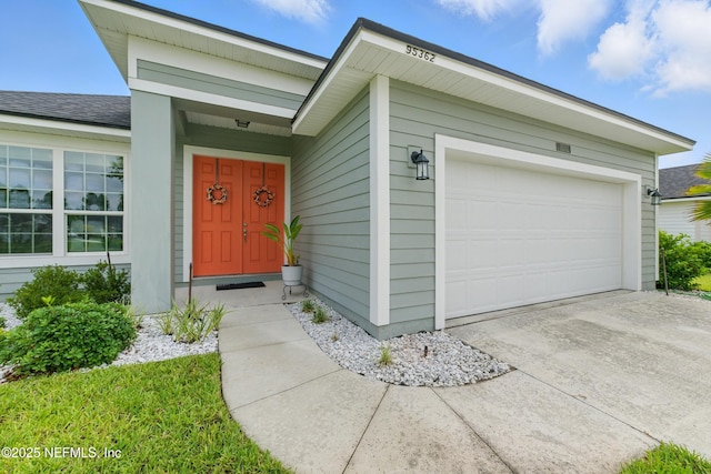 95362 Cornflower Dr, Fernandina Beach, FL 32034 - doorway to property featuring an attached garage and concrete driveway
