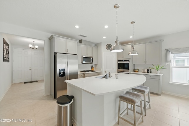 95362 Cornflower Dr, Fernandina Beach, FL 32034 - kitchen featuring stainless steel appliances, gray cabinetry, a center island with sink, recessed lighting, and a kitchen bar