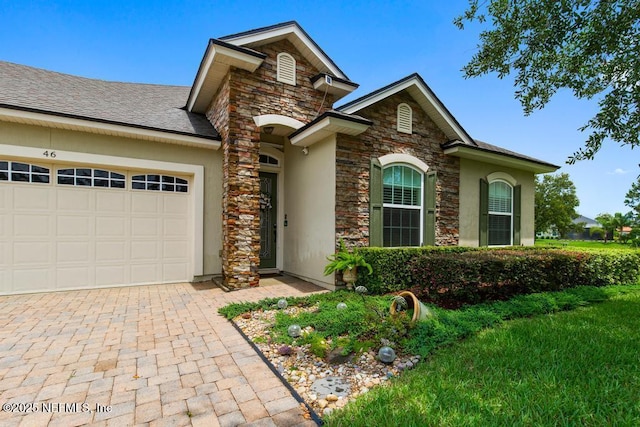 46 Gabacho Ct, Saint Augustine, FL 32095 - traditional home featuring stone siding, an attached garage, stucco siding, and decorative driveway