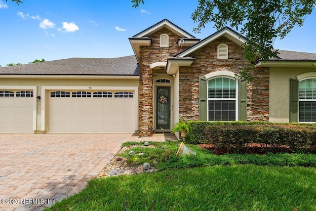 46 Gabacho Ct, Saint Augustine, FL 32095 - traditional home featuring stone siding, a garage, decorative driveway, and a shingled roof