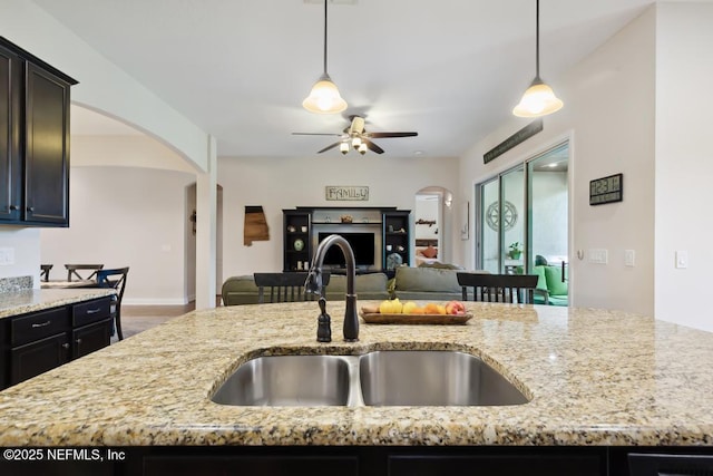 46 Gabacho Ct, Saint Augustine, FL 32095 - kitchen featuring arched walkways, ceiling fan, light stone counters, and open floor plan