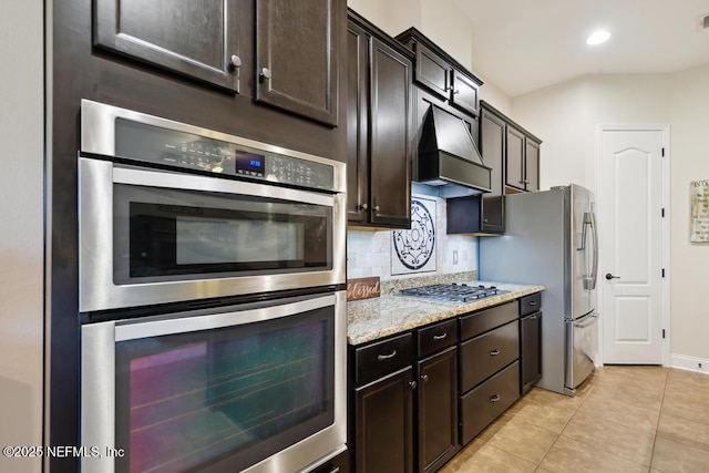 46 Gabacho Ct, Saint Augustine, FL 32095 - kitchen featuring stainless steel appliances, backsplash, light tile patterned floors, custom exhaust hood, and light stone countertops