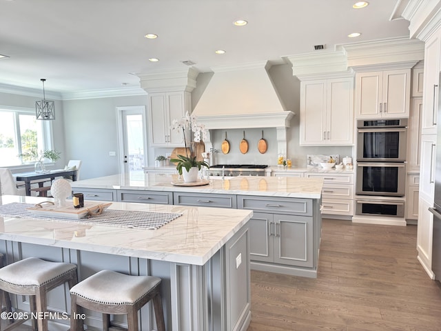 532 Atlantic Beach Ct, Atlantic Beach, FL 32233 - kitchen with a center island, stainless steel appliances, gray cabinets, recessed lighting, and custom exhaust hood