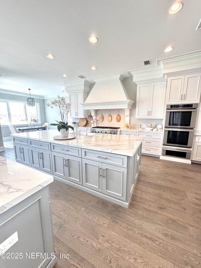 532 Atlantic Beach Ct, Atlantic Beach, FL 32233 - kitchen with premium range hood, crown molding, light wood-type flooring, recessed lighting, and gray cabinets