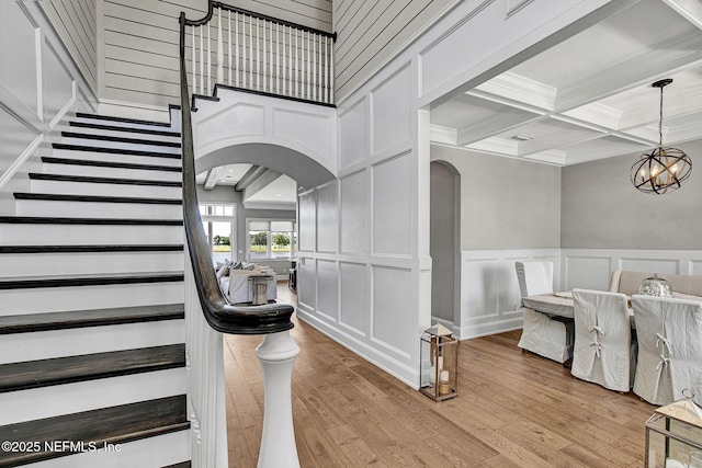 532 Atlantic Beach Ct, Atlantic Beach, FL 32233 - staircase with arched walkways, a decorative wall, ornamental molding, beam ceiling, and a chandelier