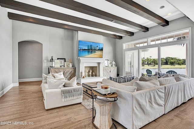 532 Atlantic Beach Ct, Atlantic Beach, FL 32233 - living room with arched walkways, beamed ceiling, light wood finished floors, recessed lighting, and a fireplace with raised hearth
