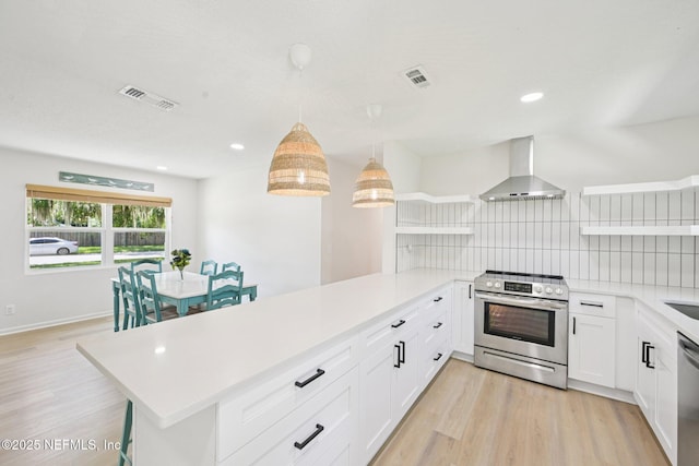 2619 Montreal St, Jacksonville, FL 32233 - kitchen with appliances with stainless steel finishes, wall chimney range hood, open shelves, a peninsula, and backsplash