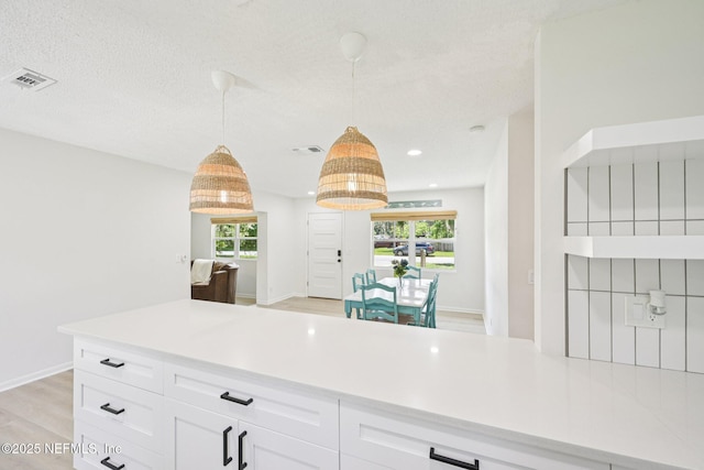 2619 Montreal St, Jacksonville, FL 32233 - kitchen featuring light countertops, white cabinetry, pendant lighting, light wood-style floors, and recessed lighting