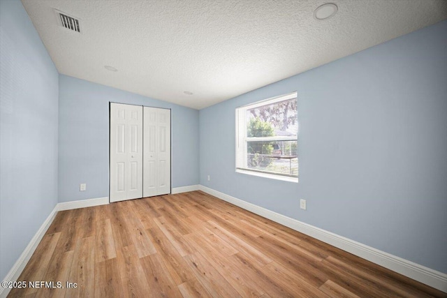 361 Mercury Dr, Orange Park, FL 32073 - unfurnished bedroom featuring light wood finished floors, a closet, a textured ceiling, and lofted ceiling