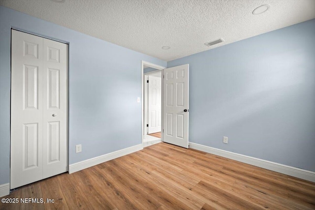 361 Mercury Dr, Orange Park, FL 32073 - unfurnished bedroom with wood finished floors, a textured ceiling, and a closet