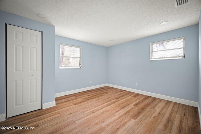 361 Mercury Dr, Orange Park, FL 32073 - unfurnished bedroom with a textured ceiling, wood finished floors, and a closet