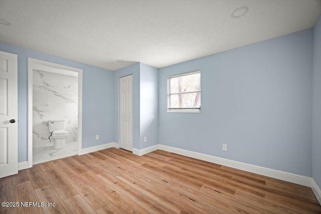 361 Mercury Dr, Orange Park, FL 32073 - unfurnished bedroom with wood finished floors, a textured ceiling, ensuite bath, and a closet
