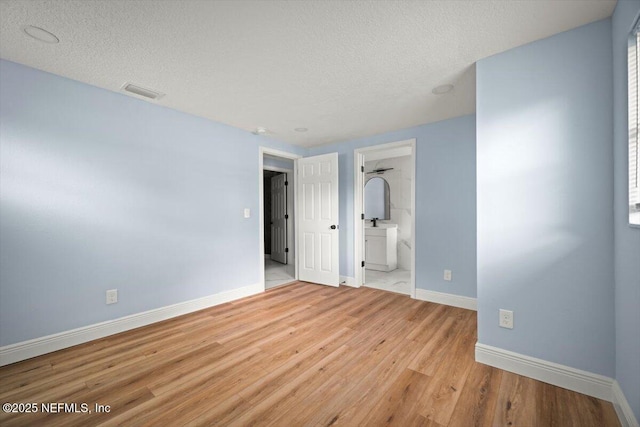 361 Mercury Dr, Orange Park, FL 32073 - unfurnished bedroom with a textured ceiling, wood finished floors, and ensuite bathroom