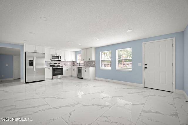 361 Mercury Dr, Orange Park, FL 32073 - kitchen with stainless steel appliances, a textured ceiling, white cabinets, light countertops, and light marble finish flooring