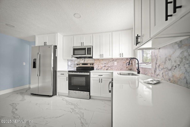 361 Mercury Dr, Orange Park, FL 32073 - kitchen featuring appliances with stainless steel finishes, light marble finish flooring, white cabinets, and a textured ceiling