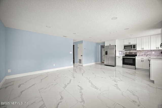 361 Mercury Dr, Orange Park, FL 32073 - kitchen featuring appliances with stainless steel finishes, a textured ceiling, open floor plan, decorative backsplash, and light marble finish floors