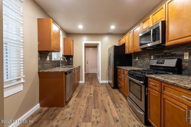 1514 Thomas St, Green Cove Springs, FL 32043 - kitchen with appliances with stainless steel finishes, a sink, baseboards, wood finished floors, and tasteful backsplash