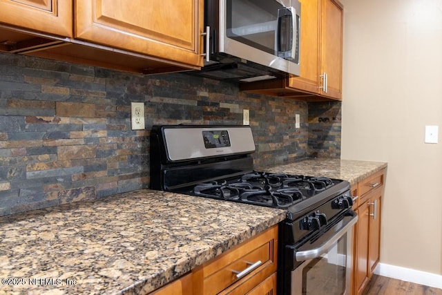 1514 Thomas St, Green Cove Springs, FL 32043 - kitchen featuring stainless steel appliances, brown cabinets, backsplash, and light stone counters