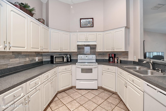 10121 SW 61st Terrace Rd, Ocala, FL 34476 - kitchen featuring white appliances, under cabinet range hood, tasteful backsplash, and dark countertops