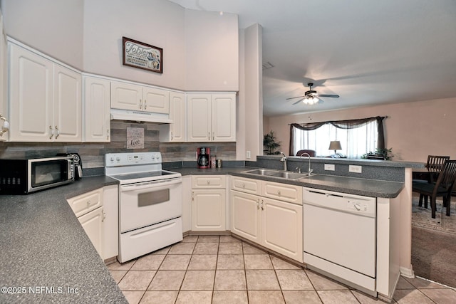 10121 SW 61st Terrace Rd, Ocala, FL 34476 - kitchen with white appliances, under cabinet range hood, light tile patterned floors, a peninsula, and dark countertops