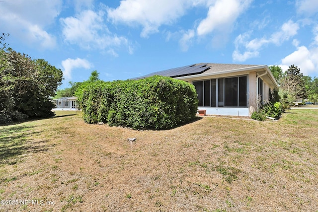 10121 SW 61st Terrace Rd, Ocala, FL 34476 - back of property with a sunroom, a lawn, and roof mounted solar panels