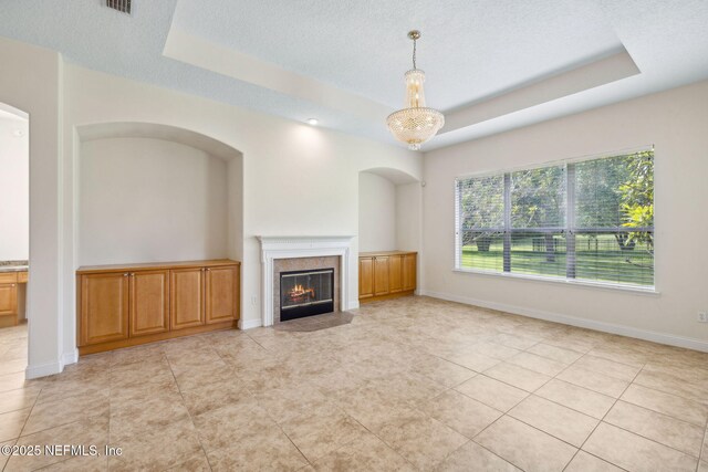 3975 Royal Pines Dr, Orange Park, FL 32065 - unfurnished living room featuring a tray ceiling, a tile fireplace, a textured ceiling, and light tile patterned floors