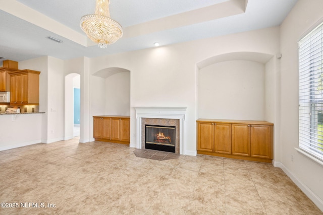 3975 Royal Pines Dr, Orange Park, FL 32065 - unfurnished living room with a chandelier, arched walkways, and a tiled fireplace