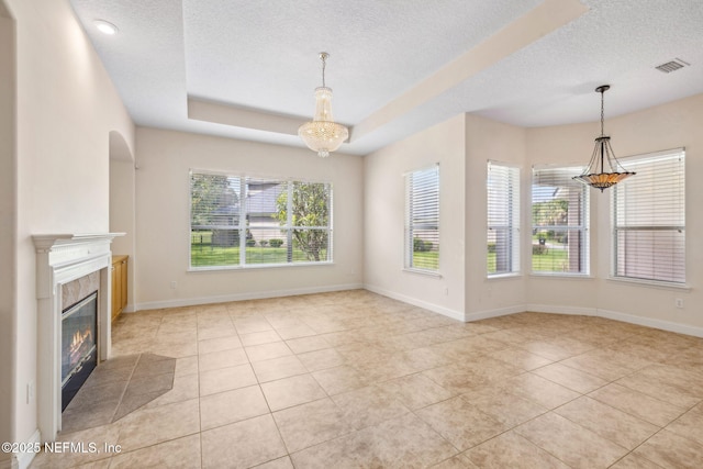 3975 Royal Pines Dr, Orange Park, FL 32065 - unfurnished living room with plenty of natural light, a textured ceiling, tile patterned flooring, and a chandelier