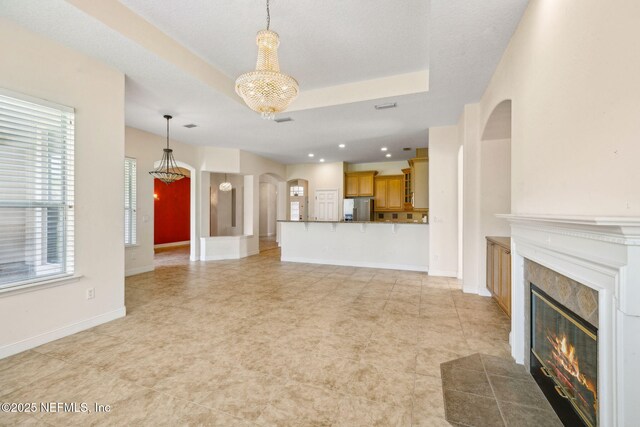 3975 Royal Pines Dr, Orange Park, FL 32065 - unfurnished living room with arched walkways, a fireplace, a chandelier, healthy amount of natural light, and recessed lighting