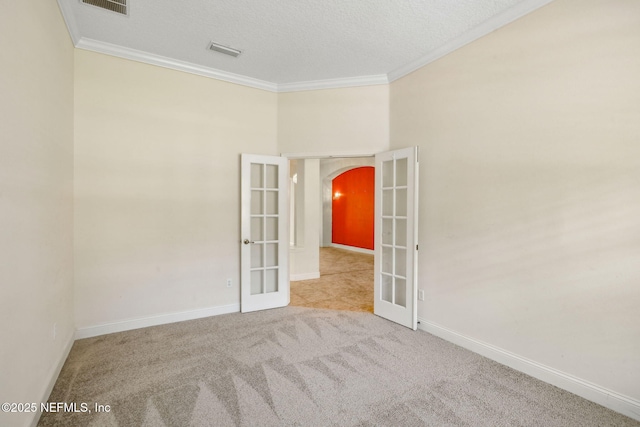 3975 Royal Pines Dr, Orange Park, FL 32065 - carpeted empty room with french doors, arched walkways, ornamental molding, and a textured ceiling