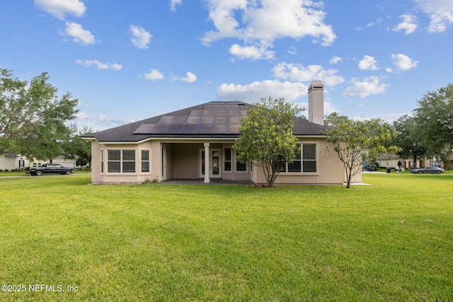 3975 Royal Pines Dr, Orange Park, FL 32065 - rear view of house featuring solar panels, a yard, a chimney, and stucco siding
