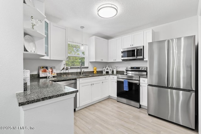 6217 Lobelia St, Jacksonville, FL 32209 - kitchen with stainless steel appliances, white cabinets, dark stone countertops, pendant lighting, and a textured ceiling