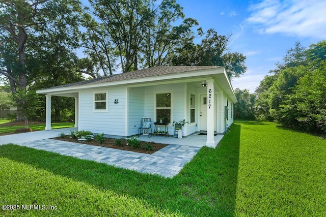 6217 Lobelia St, Jacksonville, FL 32209 - view of front of house with a front yard, a porch, roof with shingles, and concrete driveway