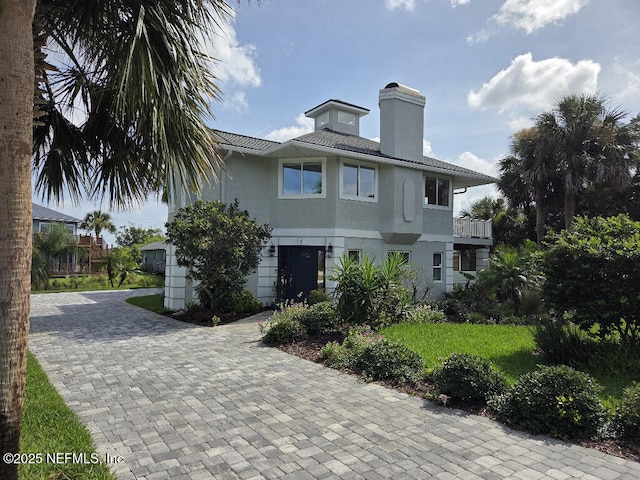 7 Sabor De Sal Rd, Saint Augustine, FL 32080 - view of front facade featuring a chimney, stucco siding, and decorative driveway